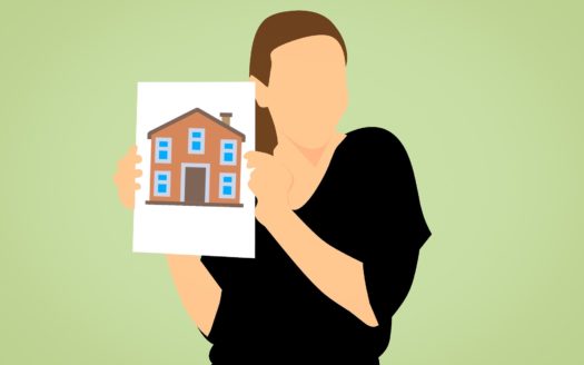a woman holding a picture of a house