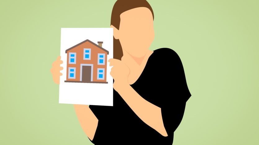 a woman holding a picture of a house